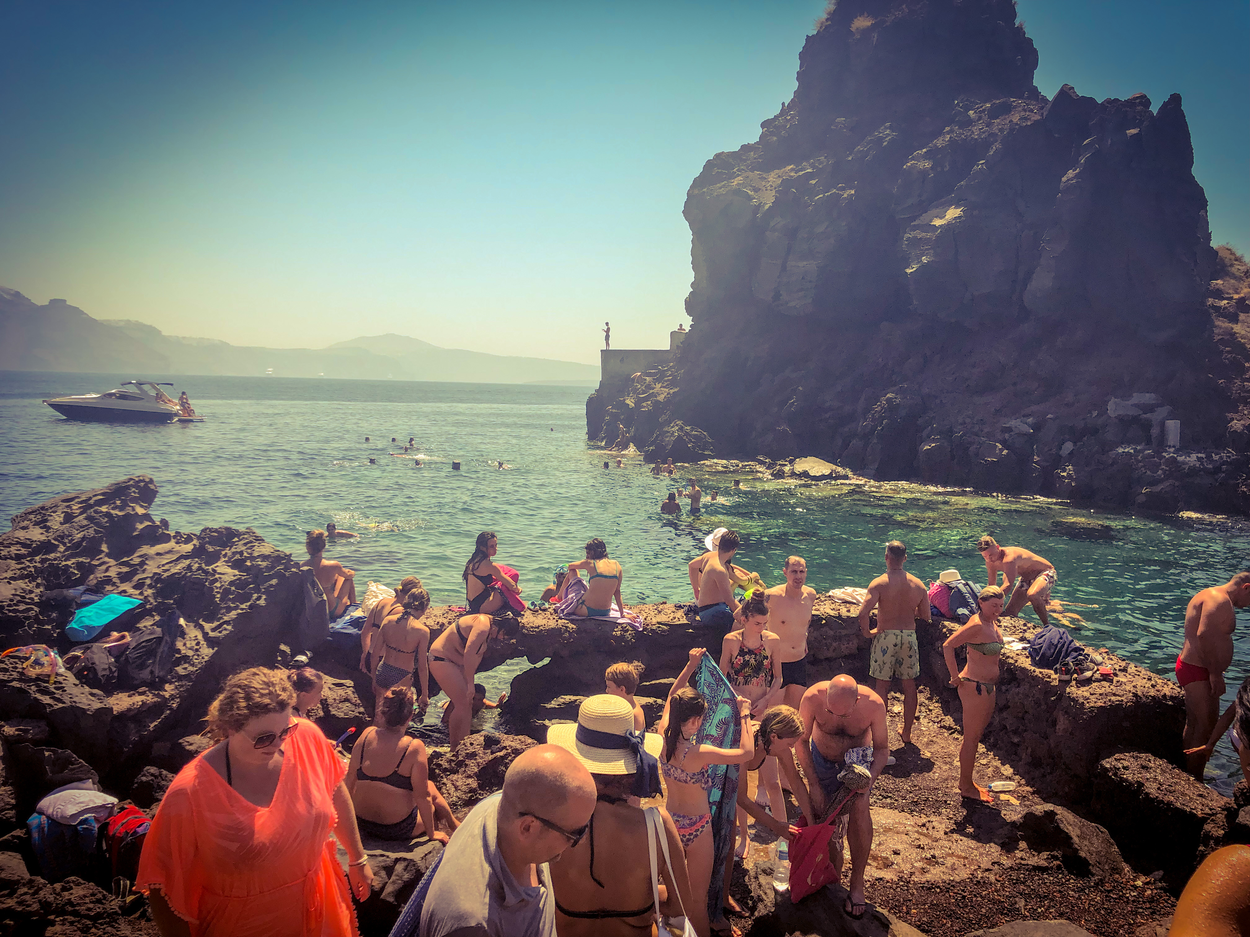 Swimming location at Amoudi Bay, Santorini with a cliff diver in the background.